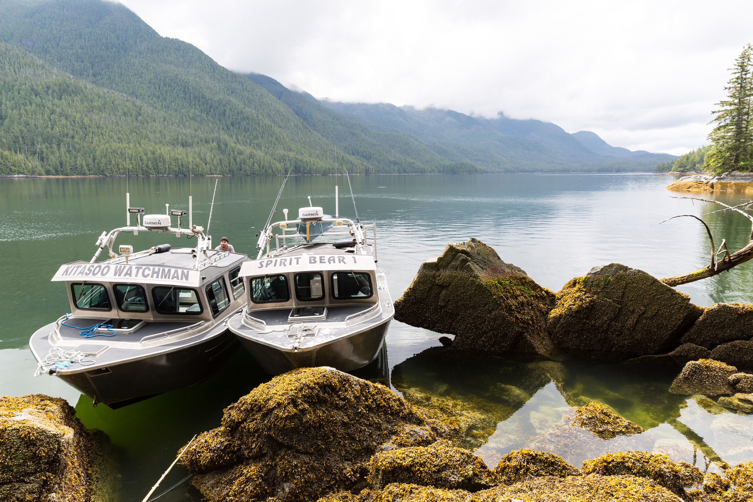 two boats parked near some boulders