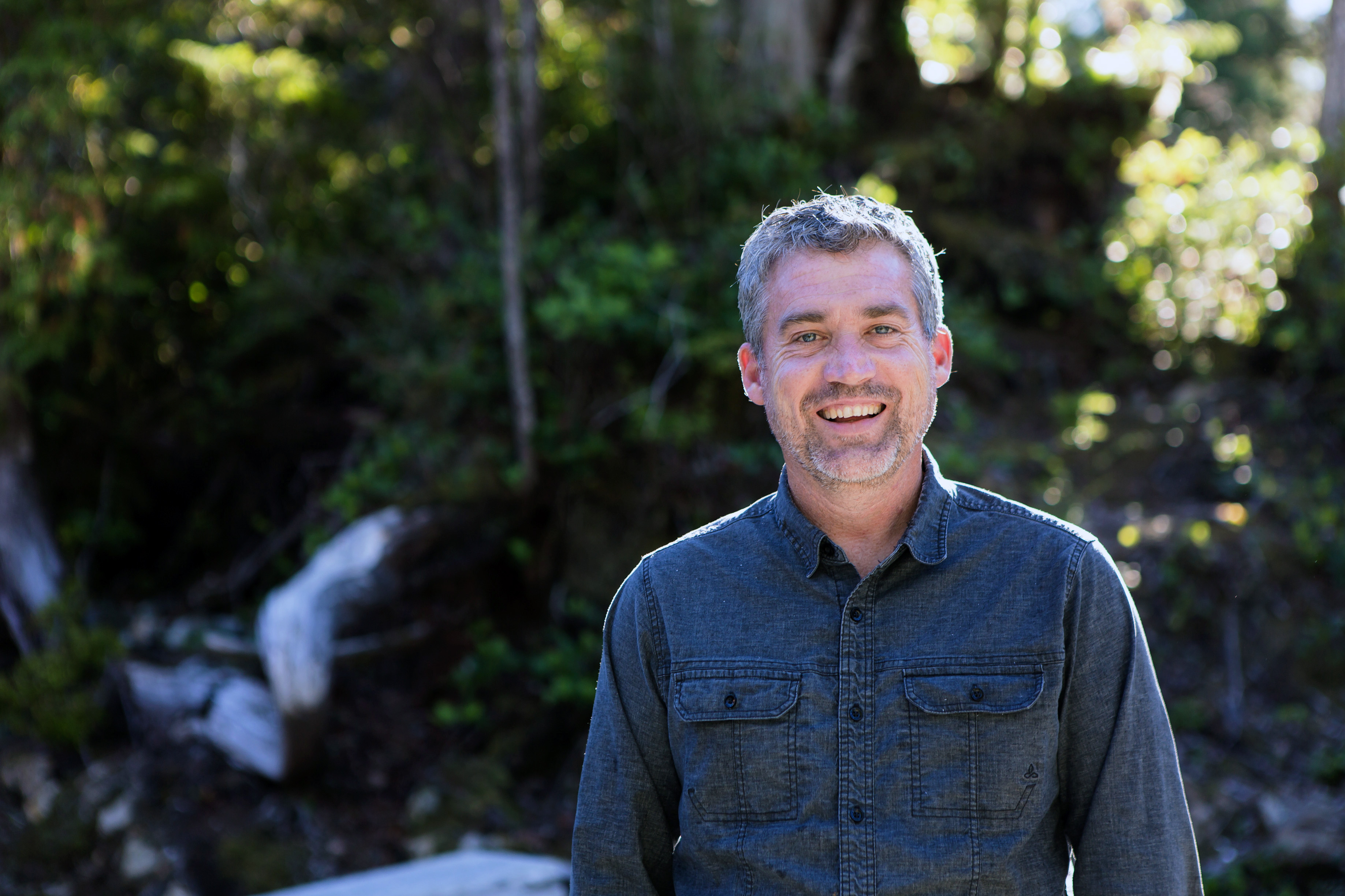 headshot of a smiling man with gray hair and a beard