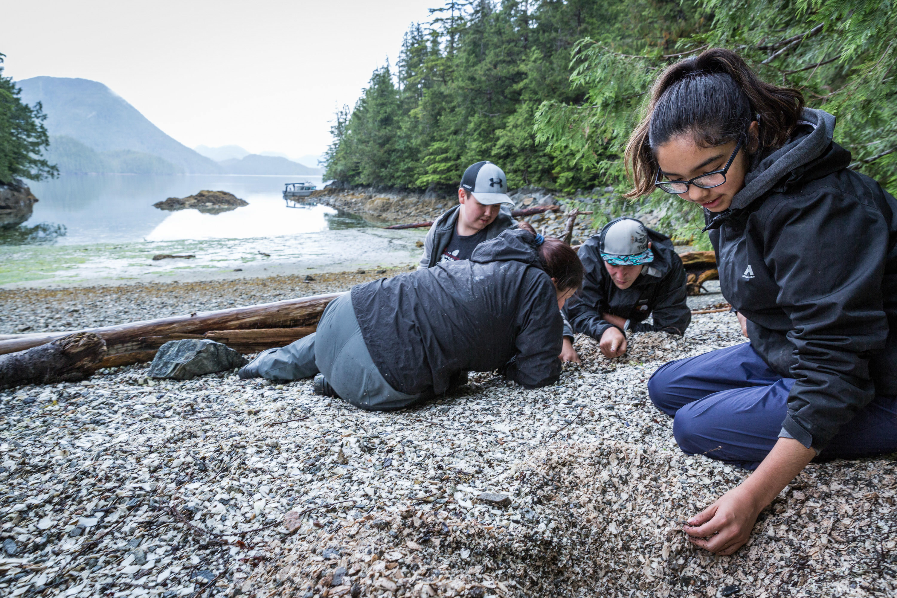 four teens on a rocky beach