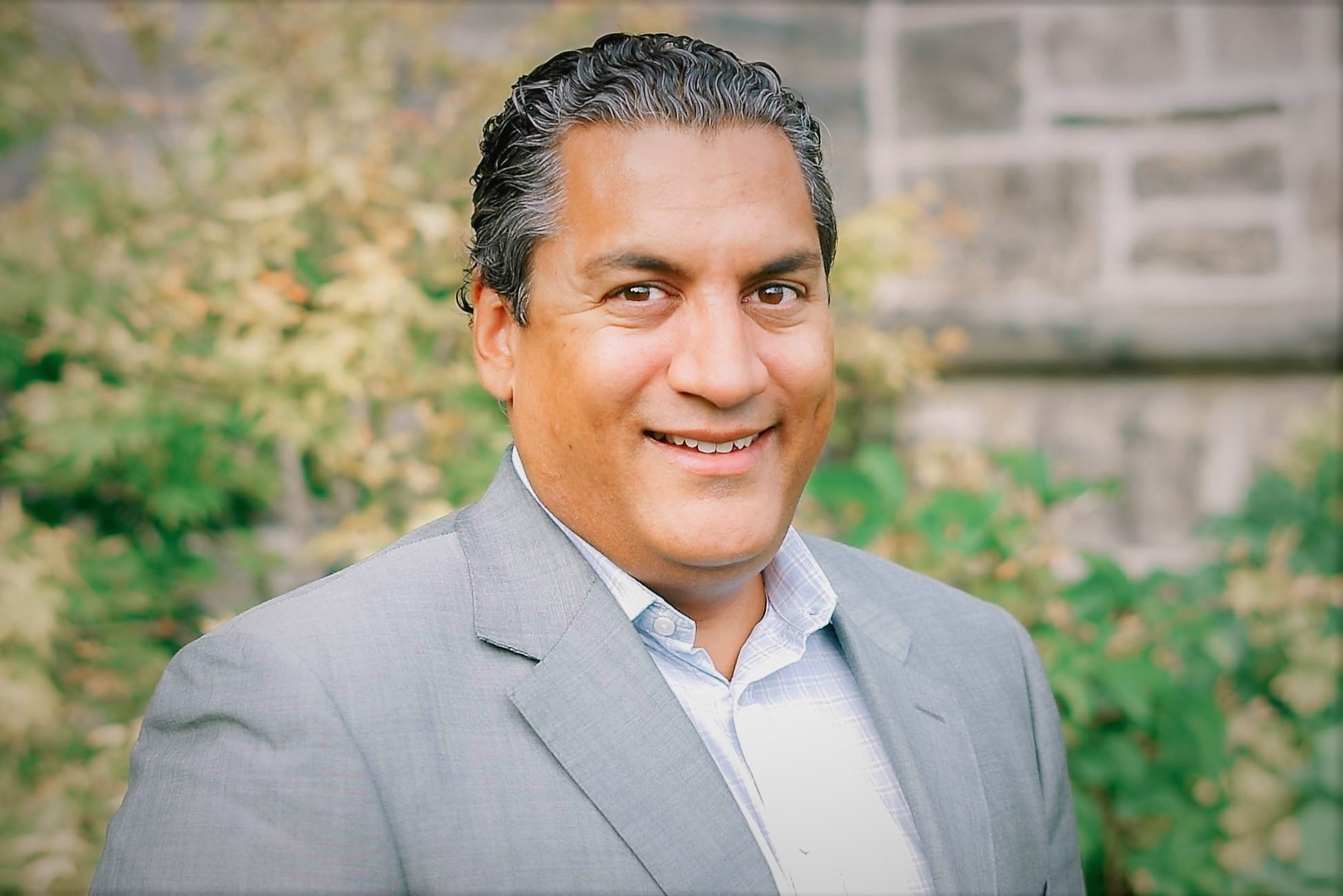 Headshot of Sasha Jacob smiling in a suit