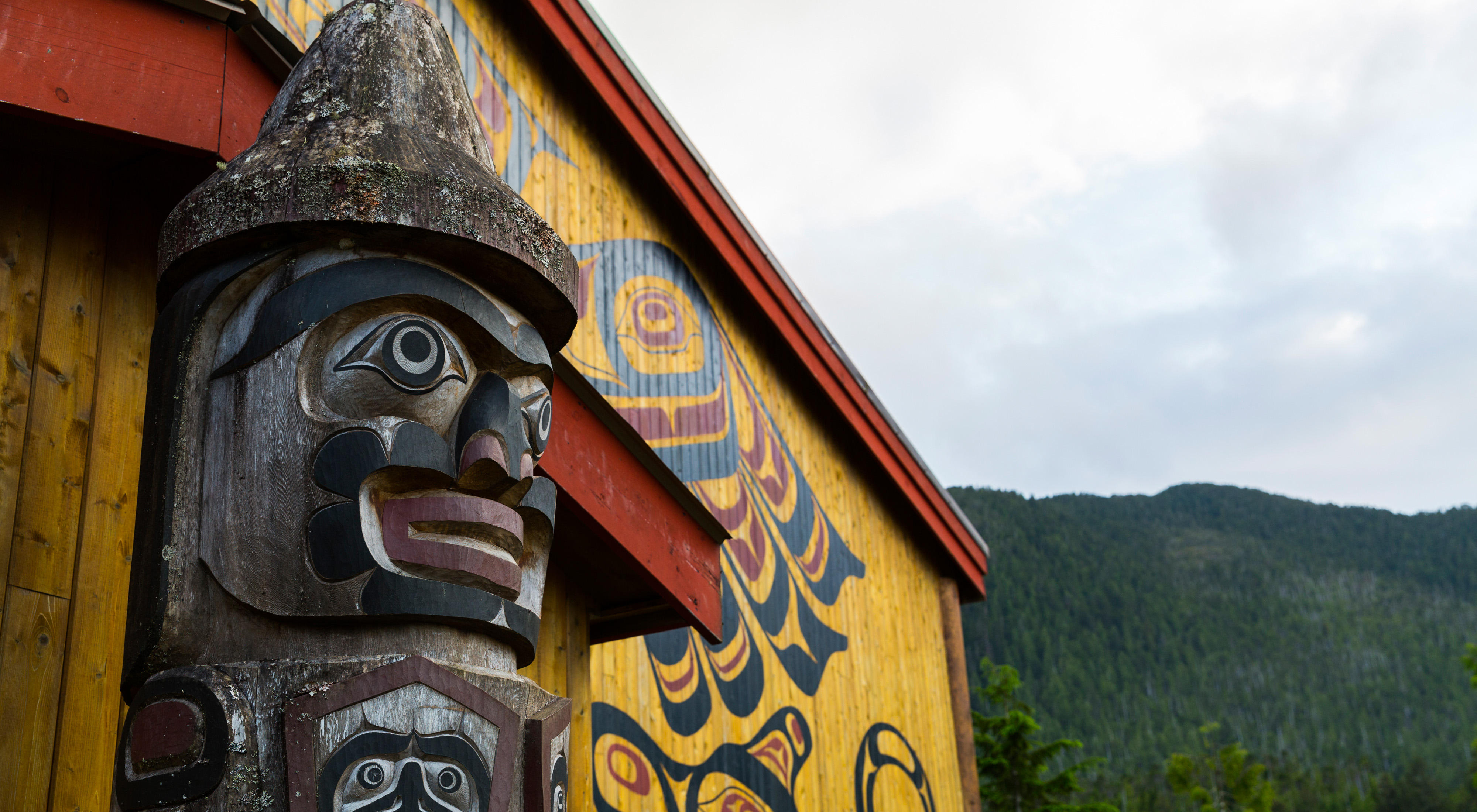 a totem pole in front of the big house in Klemtu, BC