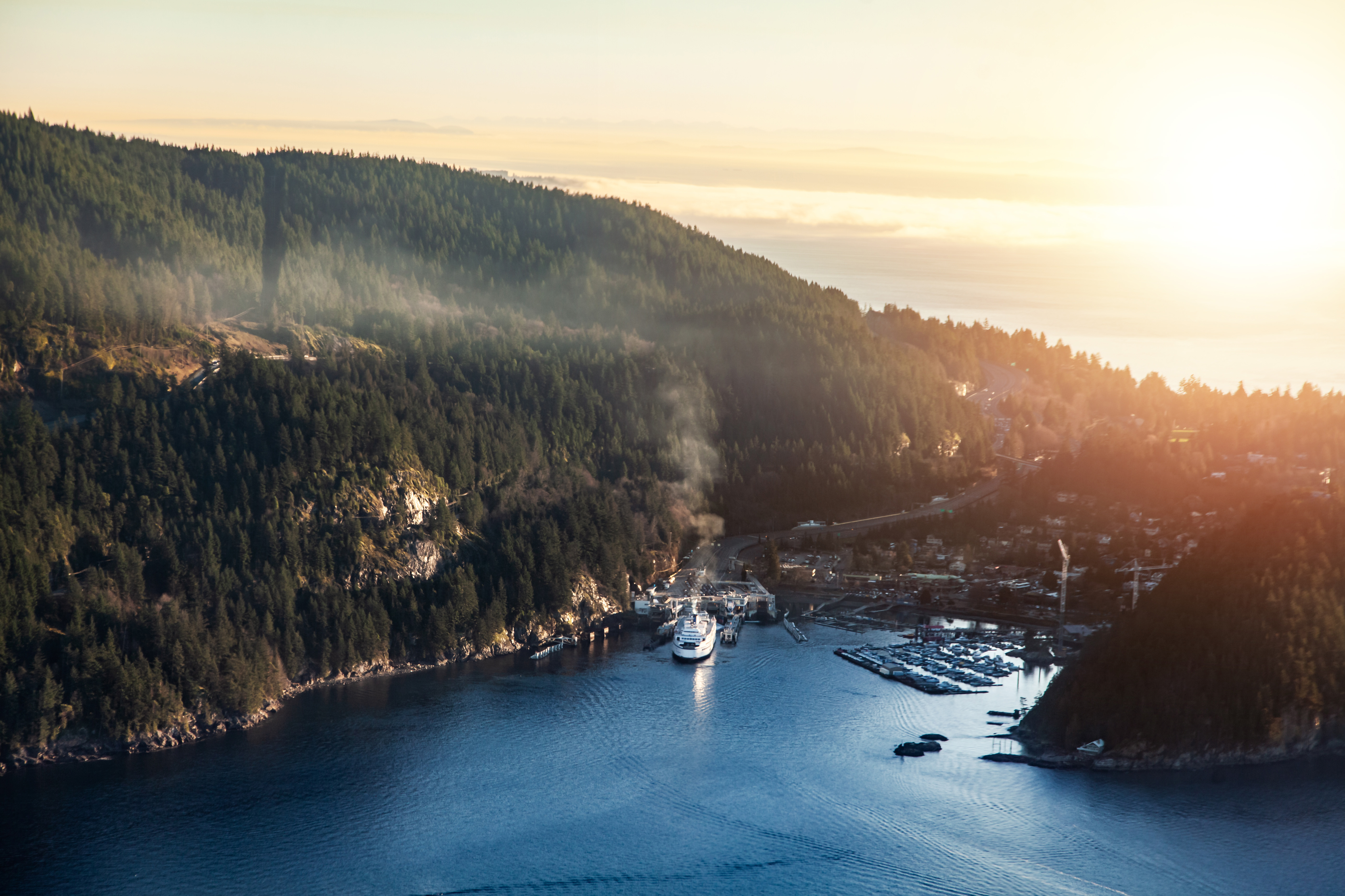 A ferry leaves from Horseshoe Bay, alive with activity on the tree-lined coast of Vancouver.